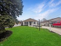 Charming single-story home with a well-manicured lawn and bright exterior paint at 447 S Bradley Ave, Indianapolis, IN 46201