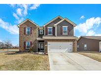 Attractive two-story home with a brick and siding facade, a two-car garage, and an inviting front yard at 491 Tracewood Bnd, Greenfield, IN 46140