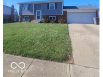 Traditional two-story home featuring a well-maintained lawn and attached two car garage at 4930 Candy Spots Dr, Indianapolis, IN 46237