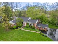 Charming aerial view of a brick house with a manicured lawn and mature trees, providing privacy and curb appeal at 8510 N Park Ave, Indianapolis, IN 46240