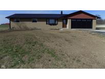 Charming single-story home with a black metal roof, two car garage and a spacious front yard at 10966 W State Road 142, Quincy, IN 47456