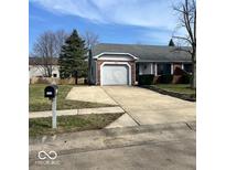 Charming single-story home with a gray brick and siding exterior, a well-manicured lawn, and an attached garage at 1127 Barbara Dr, Greenwood, IN 46143