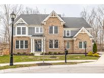 Charming two-story brick home with gray accents and a well-manicured front lawn at 11930 Lazy Oak Ct, Fishers, IN 46037
