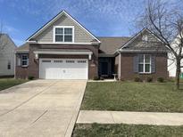 Traditional brick home with a two-car garage, well-maintained lawn, and inviting curb appeal at 1460 Tuscany Dr, Greenwood, IN 46143