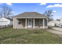 Charming one-story home featuring a covered porch, neutral siding, and a well-maintained front lawn under a clear blue sky at 3022 Alice Ave, Indianapolis, IN 46237