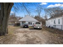 Cozy single-story home with a front yard, gravel driveway, and multiple cars parked out front at 3027 Alice Ave, Indianapolis, IN 46237