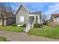 Charming gray home with a well-manicured lawn and inviting front porch with white railings at 3732 N Kenwood Ave, Indianapolis, IN 46208