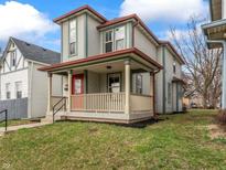 Charming two-story home with a covered front porch, freshly painted red door, and manicured front lawn at 540 N Belmont Ave, Indianapolis, IN 46222