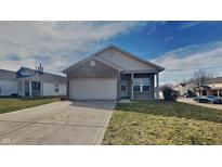 Charming single-story brick home featuring an attached garage and a well-maintained front yard at 5467 Powder River Ct, Indianapolis, IN 46221