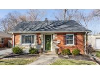 Charming brick home featuring a decorative stone accent, a green door with floral wreath, and tasteful landscaping at 5836 Brouse Ave, Indianapolis, IN 46220