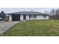 Charming single-story home with a black garage door, black front door, and a well-manicured lawn at 7408 Camby Rd, Indianapolis, IN 46113