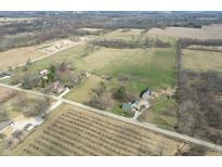 An aerial view showcases several houses, open land and tree lines at 10624 N 200 W, Alexandria, IN 46001