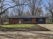 Charming single story home with a brick facade, blue door, and large front yard at 110 Pleasant Run Dr, Markleville, IN 46056