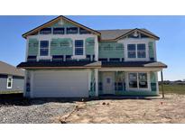 New two-story home features an attached two-car garage and covered entryway, still under construction at 1265 Fleming Dr, Greenfield, IN 46140