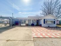 Charming single-story home with an inviting front entrance and carport at 1303 S D St, Elwood, IN 46036