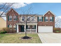 Charming two-story brick home featuring a well-manicured lawn and attached two car garage at 13150 Zinfandel Pl, Fishers, IN 46038