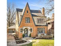 Charming brick home with peaked roof, manicured lawn, and detached two-car garage at 219 Blue Ridge Rd, Indianapolis, IN 46208