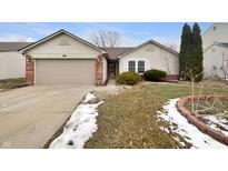 Charming single-story home with a well-maintained lawn and attached garage on a partly cloudy day at 307 Beacon Point Ln, Fortville, IN 46040