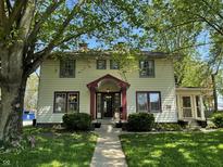 Charming two-story home with a red-accented porch and a lush green yard at 34 W Main St, Brownsburg, IN 46112