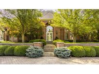 Charming brick home featuring landscaped front yard and elegant entrance at 3497 Sedgemoor Cir, Carmel, IN 46032