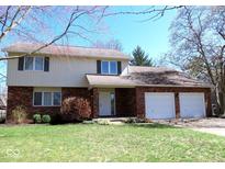 Charming two-story home with brick and siding, featuring an attached two-car garage and a well-maintained front lawn at 3705 River Rd, Columbus, IN 47203