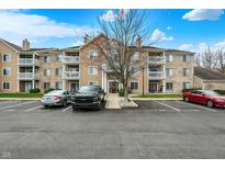 Spacious apartment building with balconies, parking spaces and beautiful landscaping and clear blue sky at 4925 Opal Ridge Ln # 309, Indianapolis, IN 46237