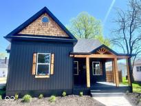 Charming home featuring dark siding, wooden accents, a covered porch, and a uniquely shaped window at 511 N Clark St, Lebanon, IN 46052