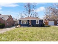 Charming single-story home with a well-maintained lawn and inviting curb appeal on a sunny day at 5884 Kingsley Dr, Indianapolis, IN 46220