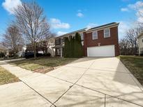 Well-maintained two-story brick home with a two-car garage and a long concrete driveway at 5895 Noble Dr, Indianapolis, IN 46234
