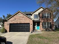 Charming two-story brick home with a two-car garage and a neatly kept front lawn at 6812 Cadwell Cir, Indianapolis, IN 46237