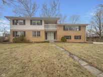 Two-story home featuring a brick and siding exterior, a small balcony, and a well-maintained front yard at 8507 Palm Ct, Indianapolis, IN 46219