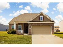 Charming brick home featuring an attached two-car garage and a well-manicured lawn at 10480 Serviceberry Dr, Indianapolis, IN 46234