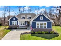 Charming blue, single-Gathering home with brick accents, manicured lawn and three dormer windows at 11072 Song Creek Ct, Fishers, IN 46040