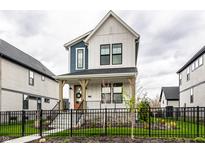 Charming two-story home with a covered front porch, black iron fence, and well-manicured landscaping at 11505 Langton Walk, Zionsville, IN 46077