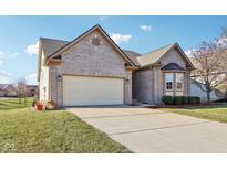 Charming brick home featuring a two-car garage and a well-maintained front yard at 12625 Broadmoor N Ct, Fishers, IN 46037