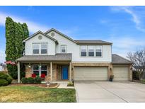 Charming two-story home showcasing a well-manicured front yard, brick accents, and a welcoming blue front door at 15192 Porchester Dr, Noblesville, IN 46062