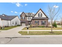 Beautiful brick home with manicured lawn, two car garage, and inviting curb appeal at 1521 Avondale Dr, Westfield, IN 46074