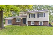 Charming two-story home featuring a brick and siding facade, well-maintained lawn and an attached garage at 1641 Whistler Terrace, Indianapolis, IN 46229