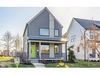 Modern two-story home features gray siding, large windows, and a welcoming porch with a bright green front door at 1955 Alvord St, Indianapolis, IN 46202