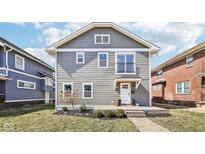 Charming two-story home featuring a welcoming front porch and stylish gray siding at 3348 Carrollton Ave, Indianapolis, IN 46205