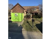 Exterior view of home with yard and green dumpster in driveway at 3655 Roxburgh N Ct, Indianapolis, IN 46234