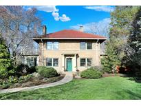 Charming two-story brick home with a red tile roof and beautiful landscaping, exuding curb appeal at 5224 Grandview Dr, Indianapolis, IN 46228