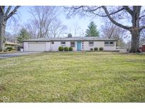 Charming ranch-style home featuring a manicured lawn, attached garage and eye-catching light blue front door at 5415 Wallace Ave, Indianapolis, IN 46220