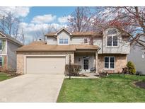 Charming two-story home with a two-car garage, brick accents, and a well-maintained front lawn at 6932 Caribou Dr, Indianapolis, IN 46278