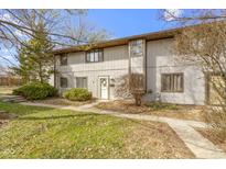 Charming townhouse featuring a well-maintained lawn, a front door wreath, and neutral-toned siding at 7965 Benjamin Dr, Lawrence, IN 46226