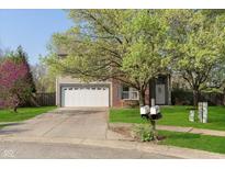 Inviting home with a two-car garage, lush lawn, and mature trees in a desirable neighborhood at 9011 Harrison Run Dr, Indianapolis, IN 46256
