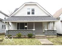 Charming home featuring a covered front porch and neutral gray siding at 1056 N Mount St, Indianapolis, IN 46222