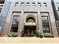 Building entrance featuring a glass door entry, well-maintained landscaping and planters at 110 E Washington St # 802, Indianapolis, IN 46204