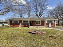 Charming red brick ranch home with a well-maintained lawn and landscaping at 1107 Heatherwood Dr, Indianapolis, IN 46241