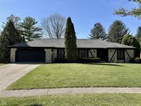 Charming one-story home with stone accents, well-manicured lawn, and mature trees at 11830 Gray Rd, Carmel, IN 46033